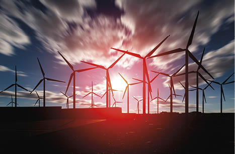 Offshore Wind Turbines Farm against a blurry sunset cloudy sky