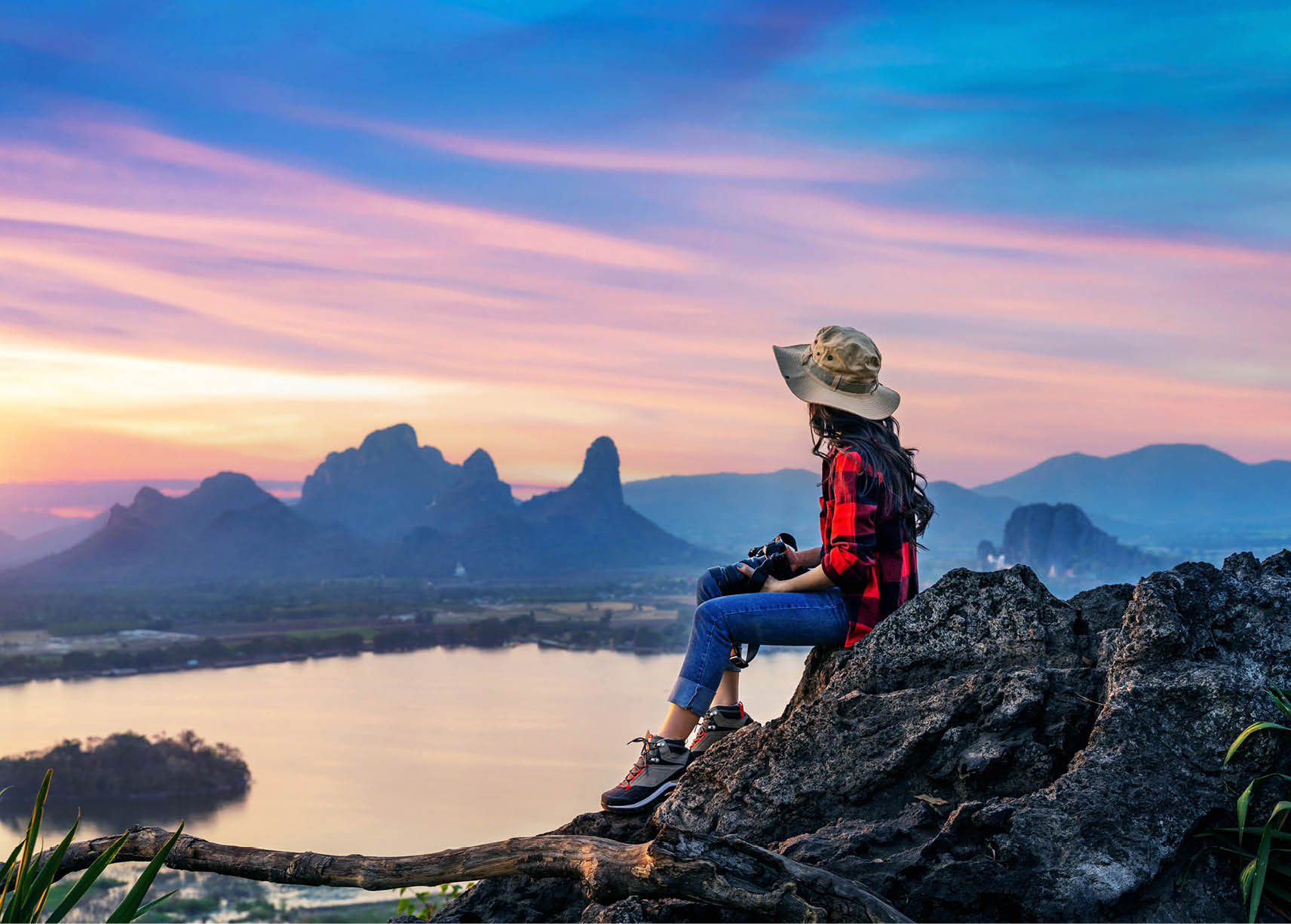 Tourist sitting on Phu sub lek viewpoint at sunset, Lopburi, Thailand.