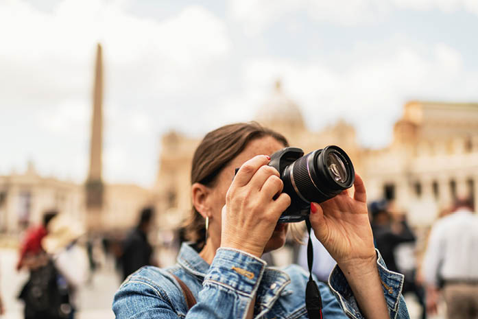 Female brunette tourist photographing architecture of an italian city.