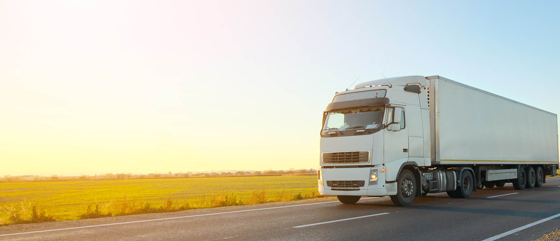 Semi-truck with cargo trailer driving on highway hauling goods in evening. Delivery transportation and logistics concept.
